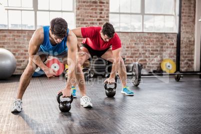 Men doing exercise with kettlebell