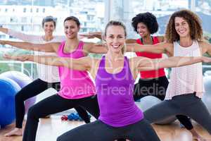 Portrait of smiling women exercising with arms outstretched