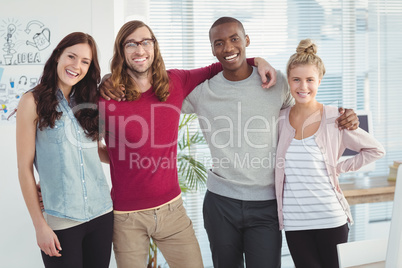 Portrait of smiling business team with arms around