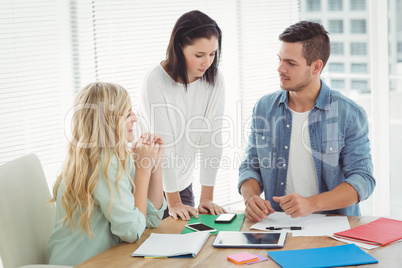 Business professionals discussing at desk