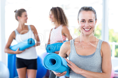 Portrait of woman holding yoga mat