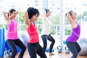 Women exercising with hands behind head