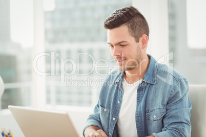 Smiling young man working on laptop