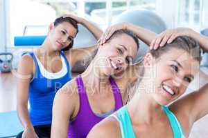 Portrait of woman doing head exercise with her friends