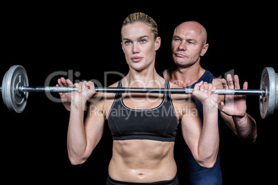 Trainer assisting woman for lifting crossfit