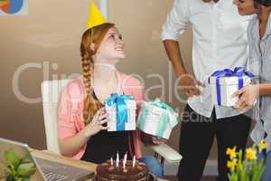 Smiling businesswoman receiving birthday gifts