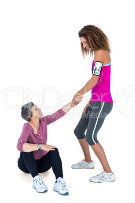 Friend assisting woman in getting up