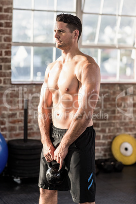 Muscular man lifting a kettlebell