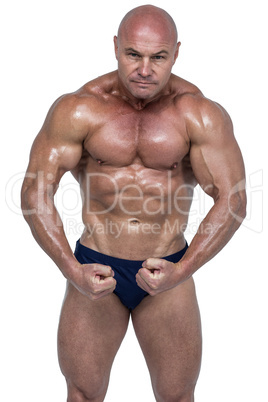 Portrait of shirtless bodybuilder flexing muscles