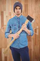 Portrait of serious hipster holding axe
