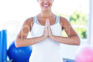 Midsection of smiling woman with hands joined