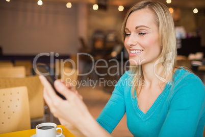 Young woman smiling while using mobile phone