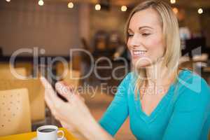 Young woman smiling while using mobile phone