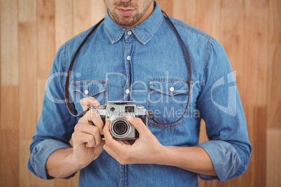 Mid section of man adjusting camera lens