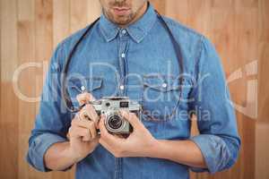 Mid section of man adjusting camera lens
