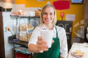 Portrait of happy female shop owner holding glass
