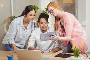 Businesswoman showing something to colleagues on digital tablet