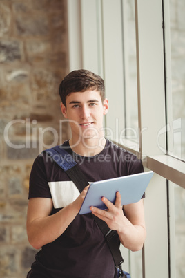 Portrait of male student using digital tablet