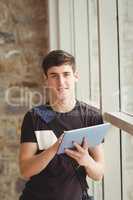 Portrait of male student using digital tablet