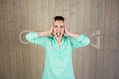 Portrait of woman screaming with head in hands