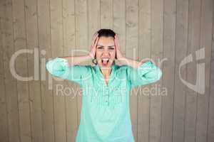 Portrait of woman screaming with head in hands