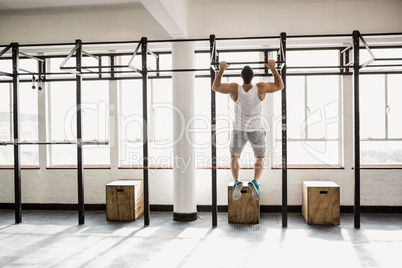 Rear view of muscular man doing pull ups