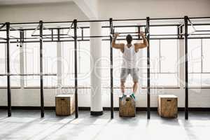 Rear view of muscular man doing pull ups
