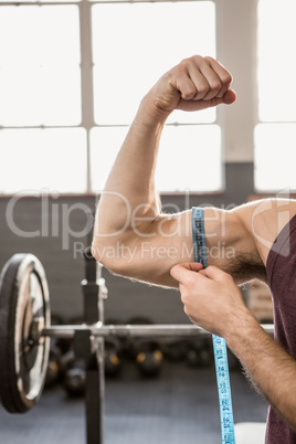 Cropped image of man measuring biceps