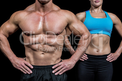 Midsection of man and woman with hands on hip