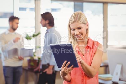 Smiling businesswoman using digital PC in office