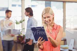 Smiling businesswoman using digital PC in office