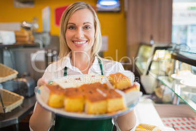 Happy female worker serving pastries