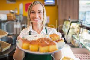 Happy female worker serving pastries