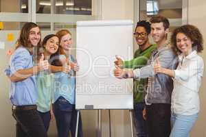 Smiling business people showing thumbs up