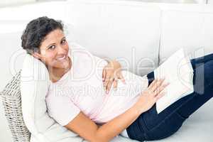 Portrait of happy pregnant woman with book