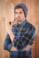 Portrait of hipster holding smoking pipe