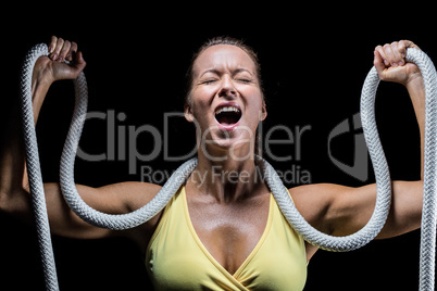 Angry woman holding rope around neck with arms raised