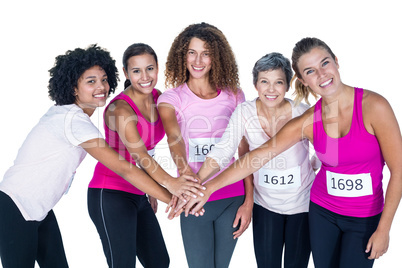 Portrait of smiling athletes putting their hands together