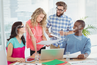 Happy business people discussing at desk