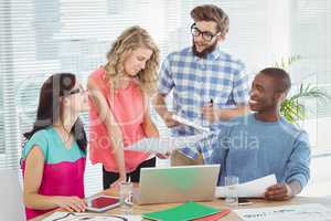 Happy business people discussing at desk