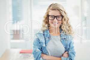 Portrait of happy businesswoman wearing eyeglasses with arms cro