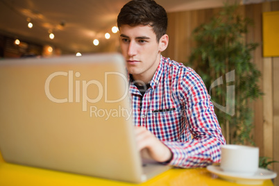 Concentrated young man using laptop
