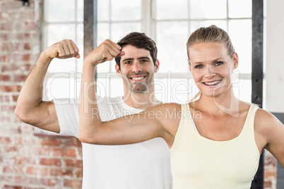 Portrait of couple flexing muscles