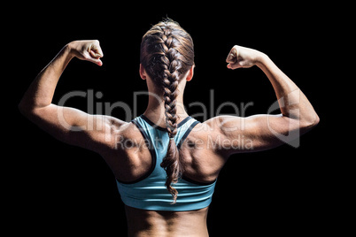 Rear view of woman with braided hair flexing muscles