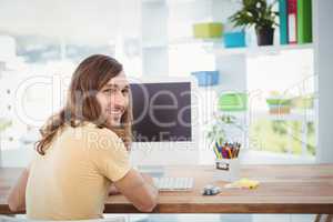 Portrait of happy hipster working at computer desk
