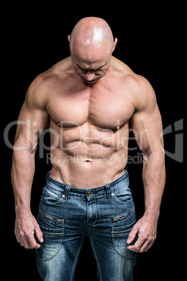 Muscular sad man looking down