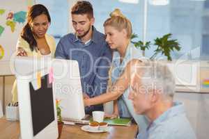 Business people using computer as male colleague working
