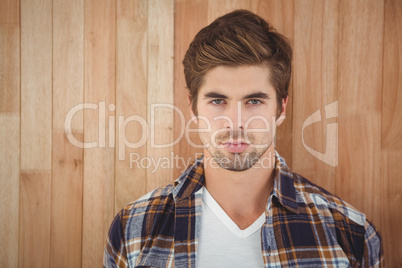 Portrait of confident man against wooden wall
