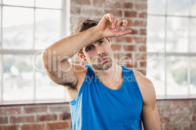 Man wiping his forehead with arm