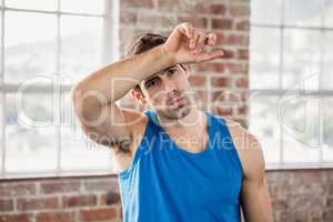 Man wiping his forehead with arm
